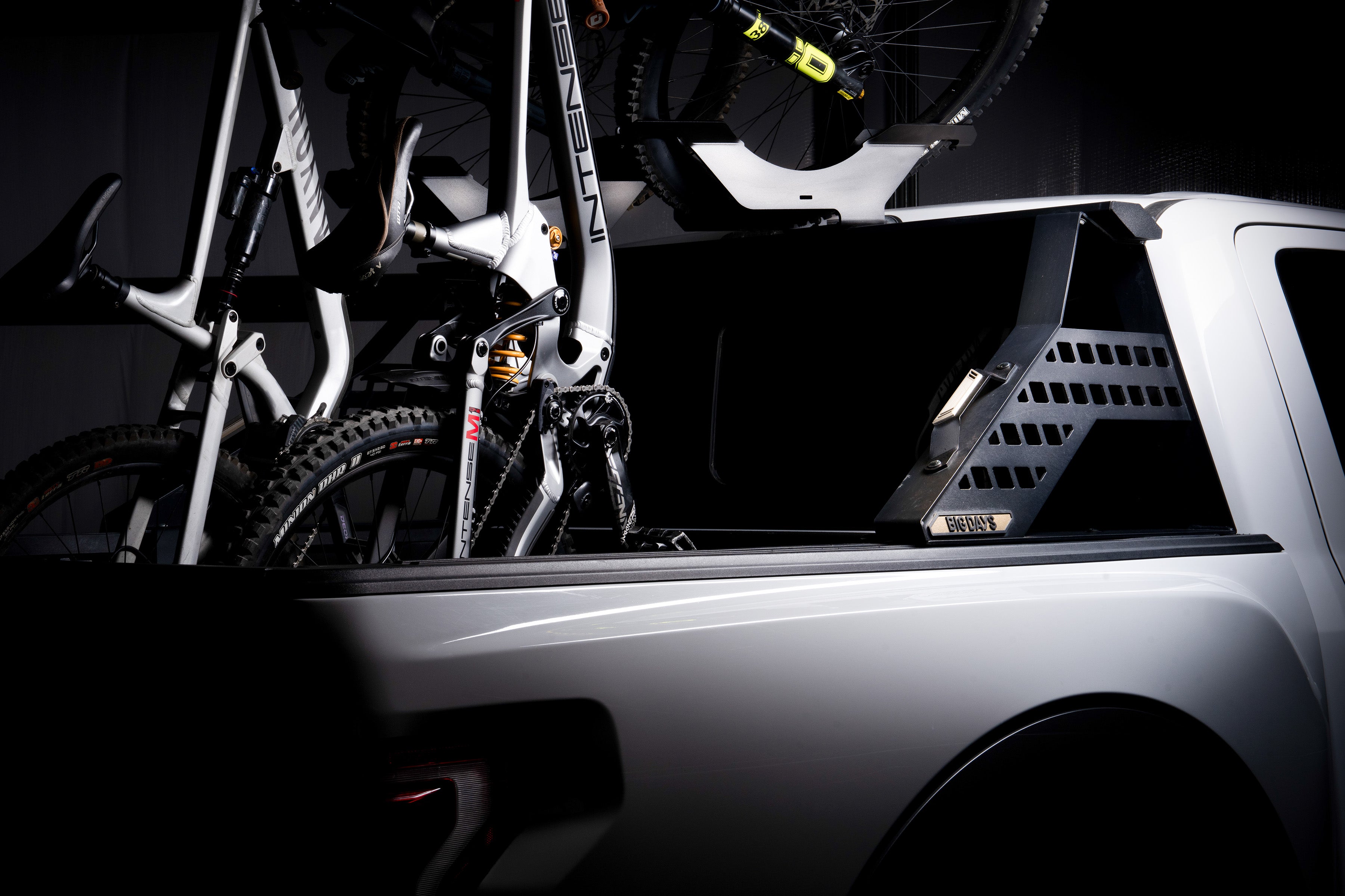 Mountain bikes and bicycles mounted in a truck bed vertically in a truck bed bike rack
