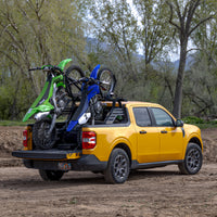 A Ford Maverick with a Big Days Chase Rack System that holds two dirt bikes in a Ford Maverick with the tailgate up