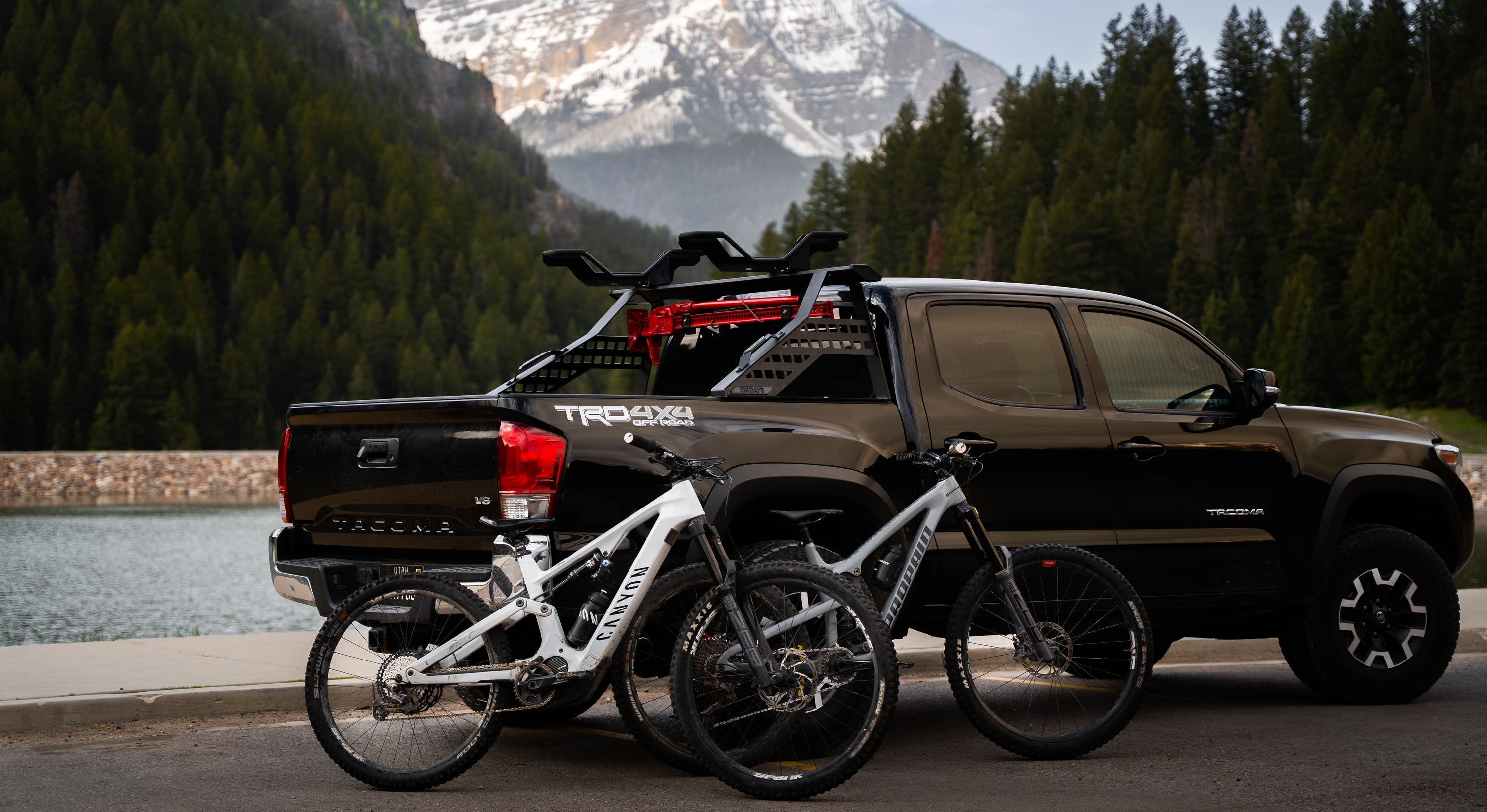 A Toyota Tacoma with a truck bed bike rack and two mountain bikes in the mountains 